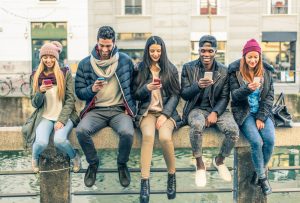 Multicultural group of friends using cellphones